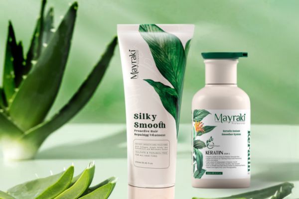Two Mayraki hair care products—a Silky Smooth Proactive Hair Repairing Treatment and a Keratin Restore Conditioner—are displayed against a soft green background with aloe vera leaves, highlighting natural ingredients and targeted hair care for high-porosity hair.