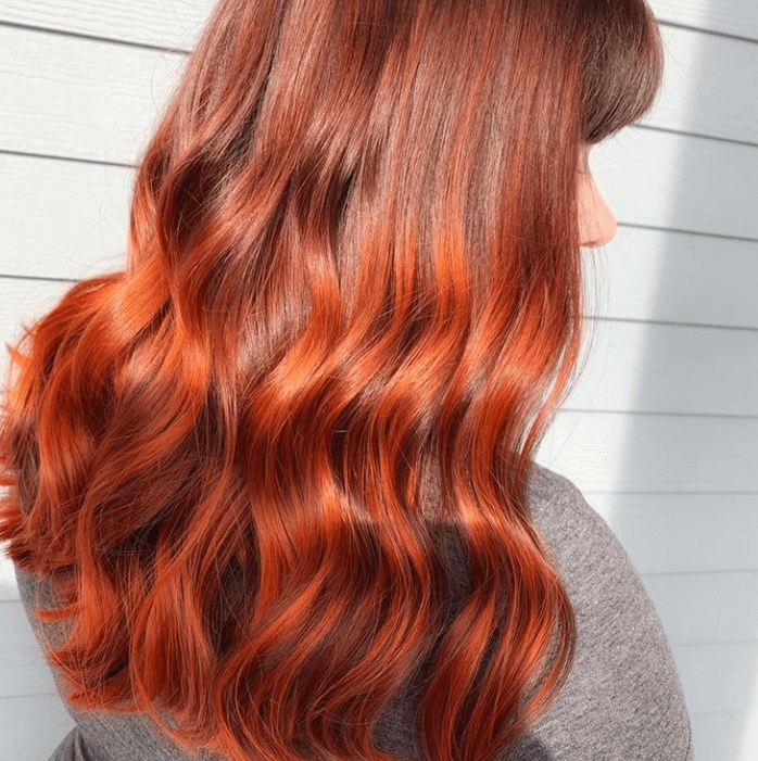 Curly vibrant reddish orange hair