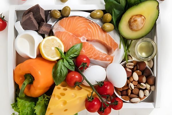 Tray filled with nutrient-rich foods that support hair health and color, including salmon, avocado, eggs, nuts, cheese, cherry tomatoes, bell pepper, leafy greens,