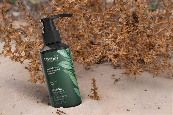 Why Pair Diet with the Mayraki Anti-Grey Treatment Hair Color Restoring Treatment Hair Mayraki’s Anti-Gray Hair Color Restoring Treatment is displayed upright in sandy terrain with dried plants in the background. The earthy setting underscores the product’s natural formulation and its role in restoring hair vitality and pigment.